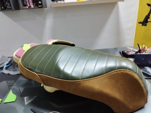 Silla de moto con tapizado verde y marrón, detalles en los laterales.